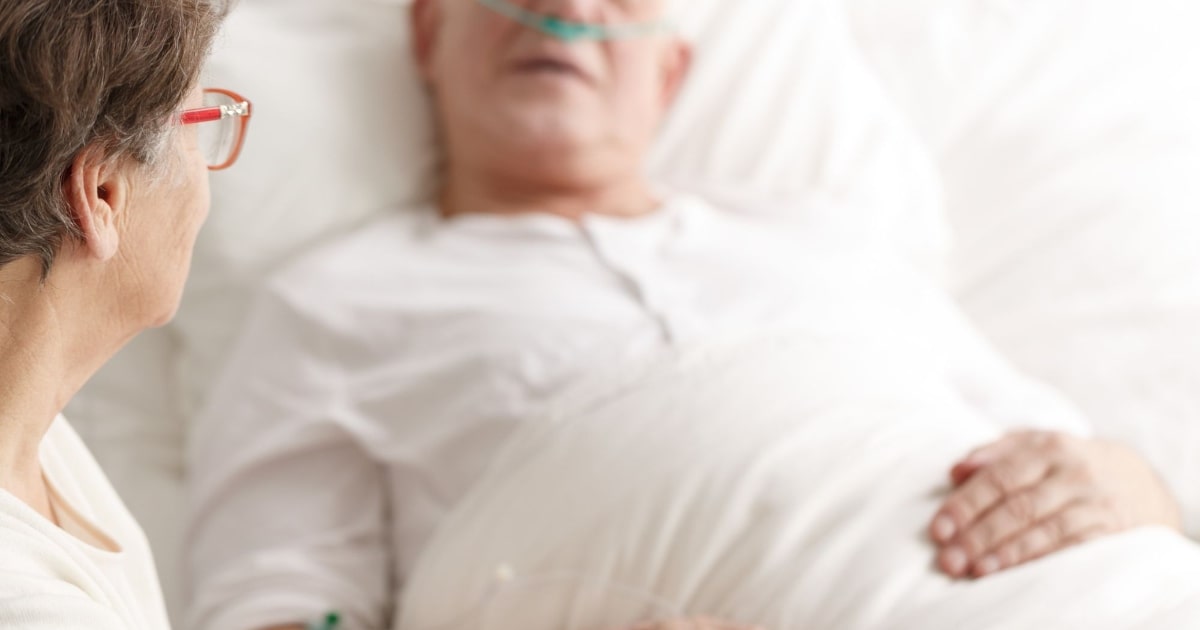 A person providing emotional support to a patient, illustrating the experience of dying at home.