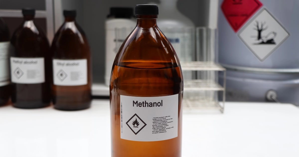 Brown glass bottle of methanol, one of the key chemicals used in embalming and body preservation.